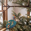 Laser-cut maple wood Helmeted Guineafowl folk art ornament O503 hanging on a fir branch, made in USA
