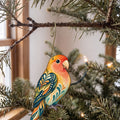 Laser-cut maple wood Peach-Faced Lovebird folk art ornament O514 hanging on a fir branch, made in USA