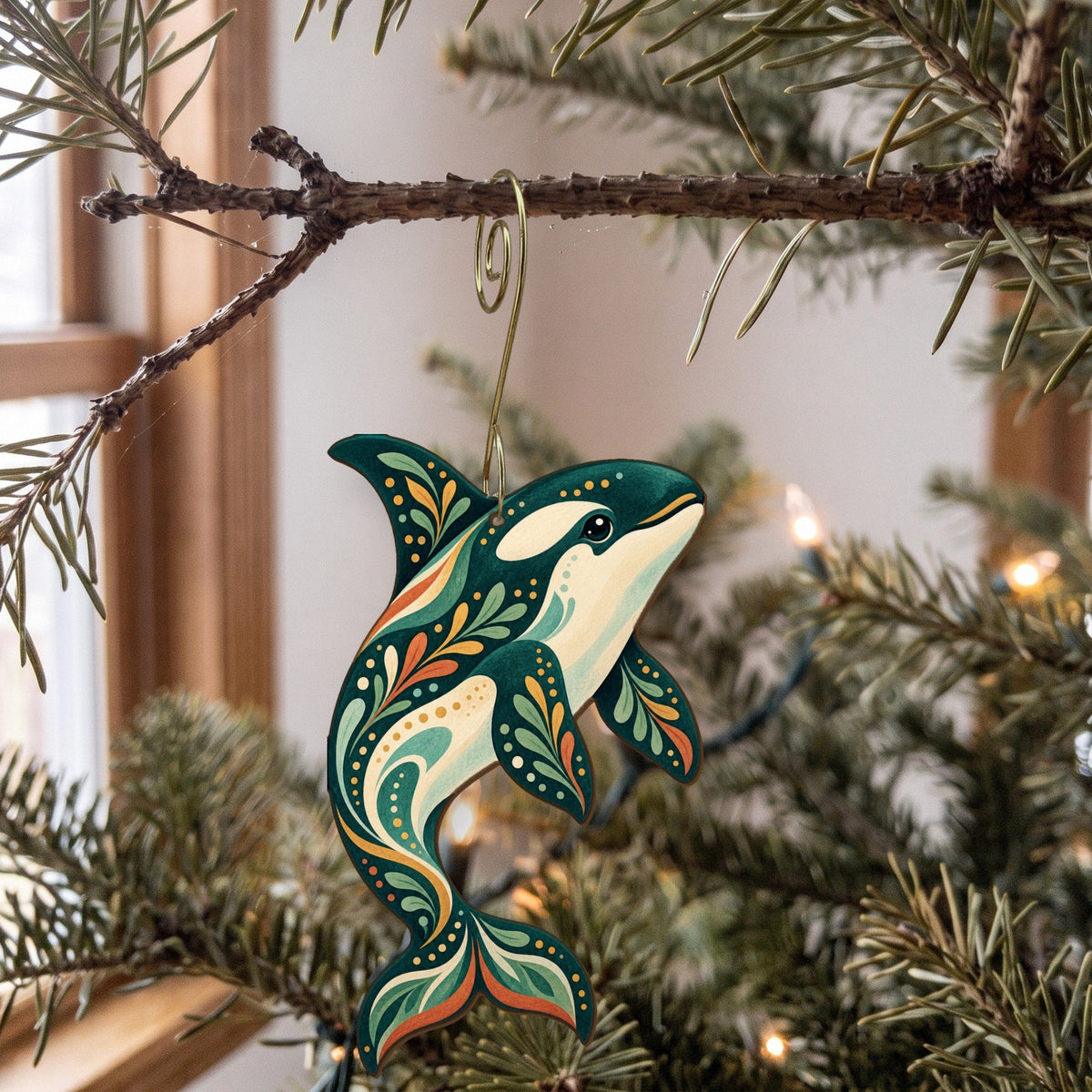 Laser-cut maple wood Orca folk art ornament O91 hanging on a fir branch, made in USA