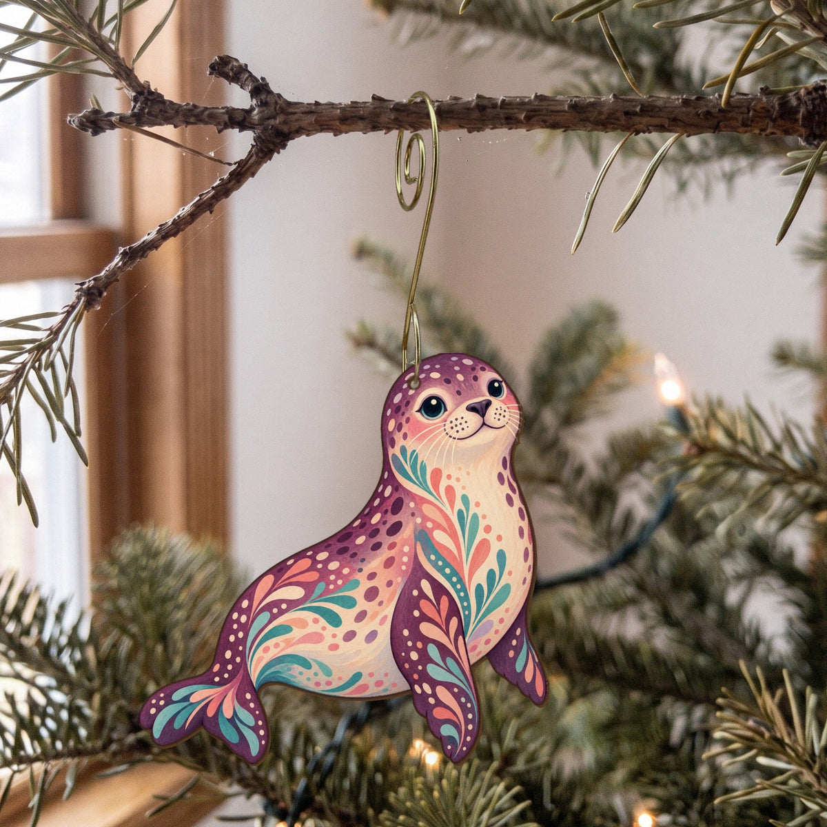 Laser-cut maple wood Harbor Seal folk art ornament O92 hanging on a fir branch, made in USA
