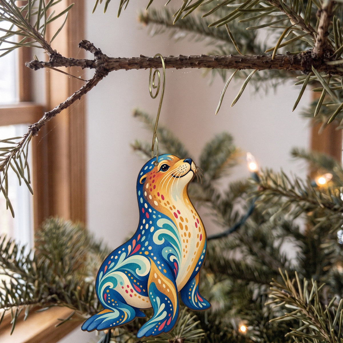 Laser-cut maple wood Sea Lion folk art ornament O93 hanging on a fir branch, made in USA