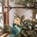 Laser-cut maple wood Sea Otter folk art ornament O95 hanging on a fir branch, made in USA