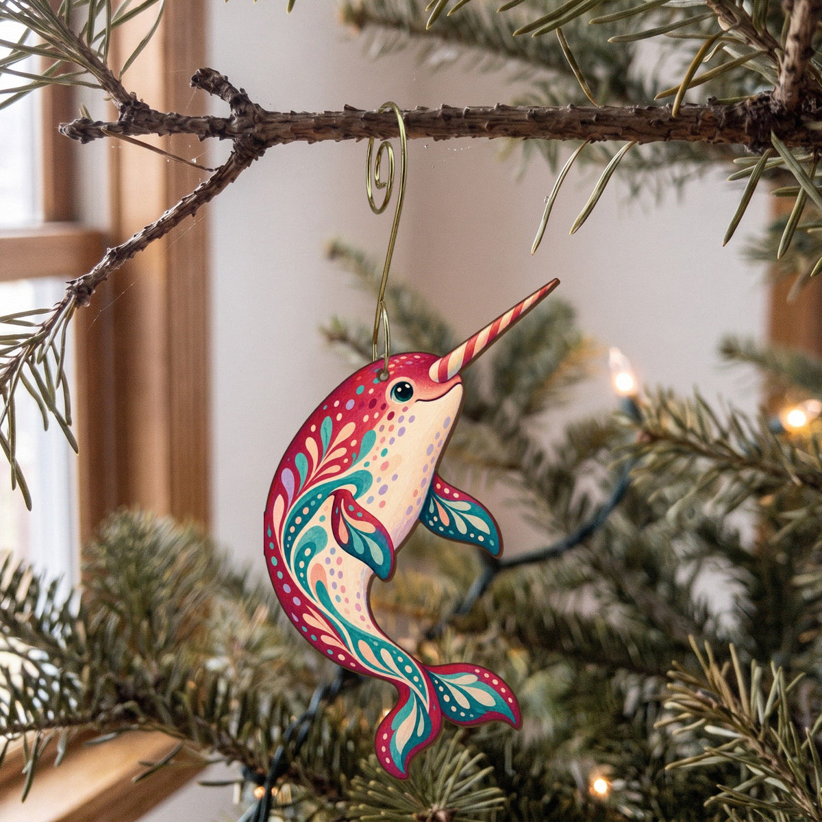 Laser-cut maple wood Narwhal folk art ornament O96 hanging on a fir branch, made in USA