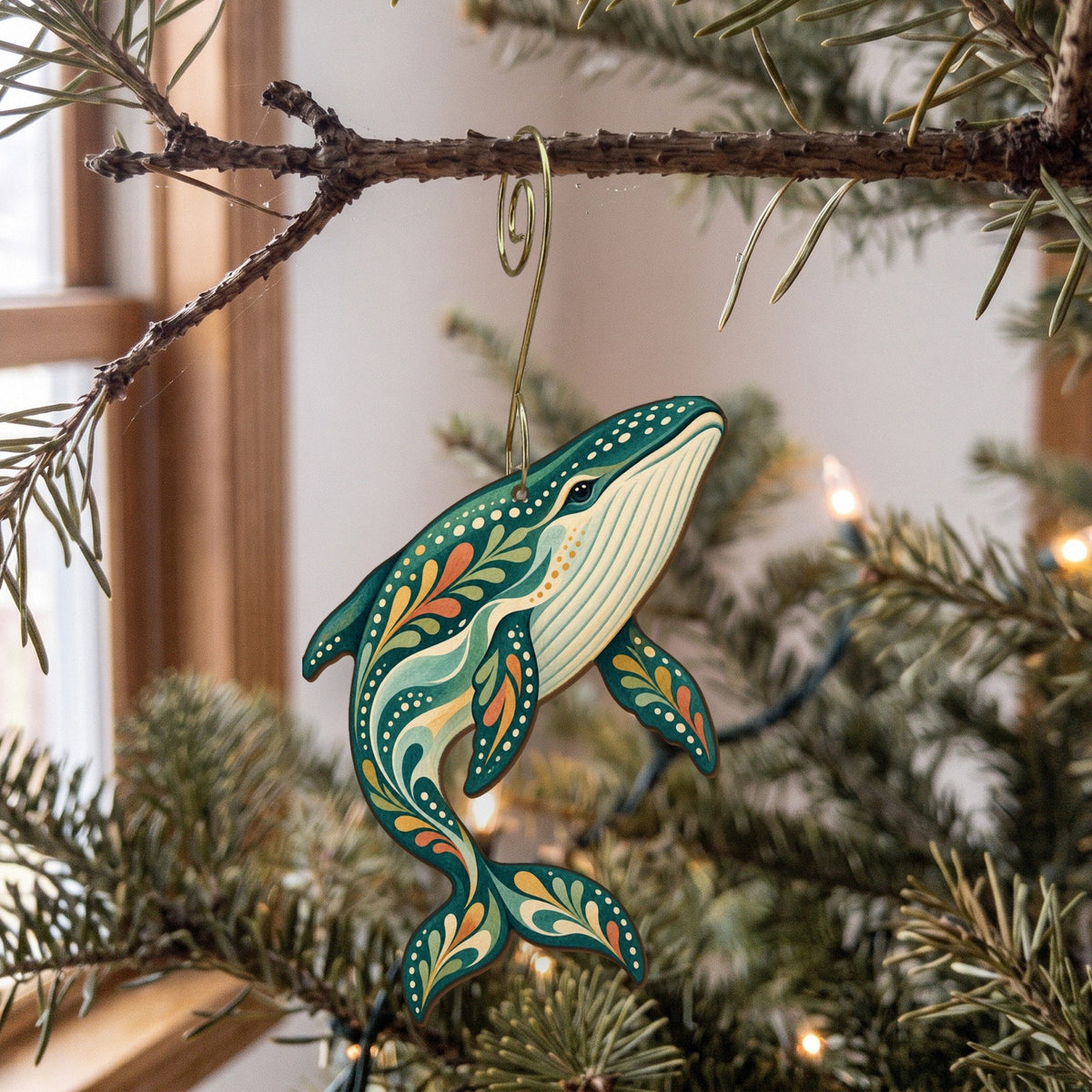 Laser-cut maple wood Blue Whale folk art ornament O99 hanging on a fir branch, made in USA