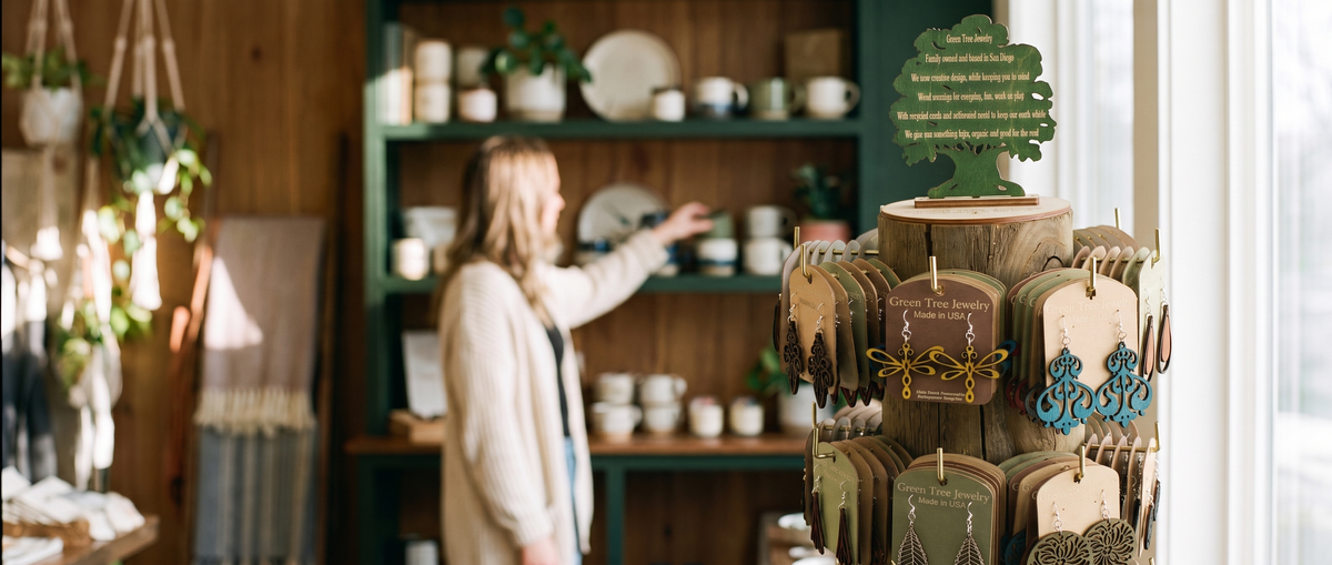 Homepage hero round 2 - R2-A - GTJ log rack spinner display in a boutique, shopper behind